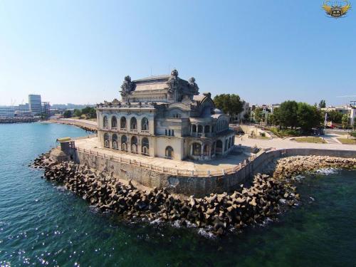 un edificio en el agua con un montón de pájaros alrededor en Apartament Central, en Constanţa