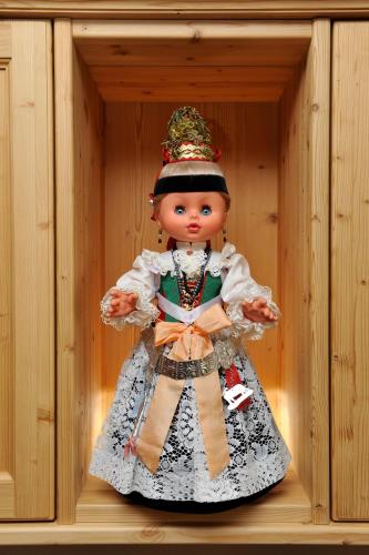 a doll in a wooden box in a wooden shelf at Garni Lanzinger in Selva di Val Gardena