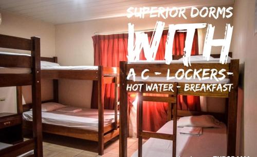 a room with three bunk beds and a sign that says milk at Hotel La Choza Inn in Fortuna