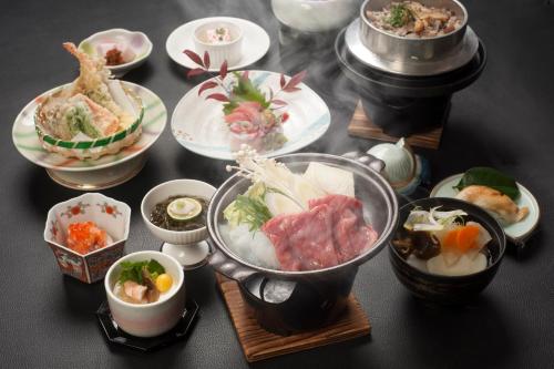 una mesa cubierta con tazones de comida y platos de comida en Musashibou, en Hiraizumi