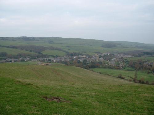 a green hill with a town in the distance at The Pebbles - Adults Only in Weymouth