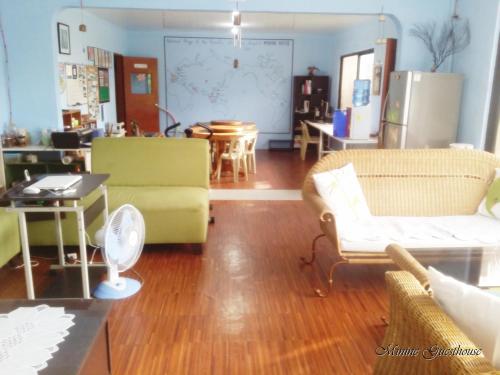 a living room with yellow chairs and a table at Minine Guesthouse in Silang