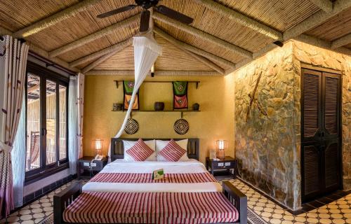 a bedroom with two beds and a ceiling fan at Mai Chau Ecolodge in Mai Chau