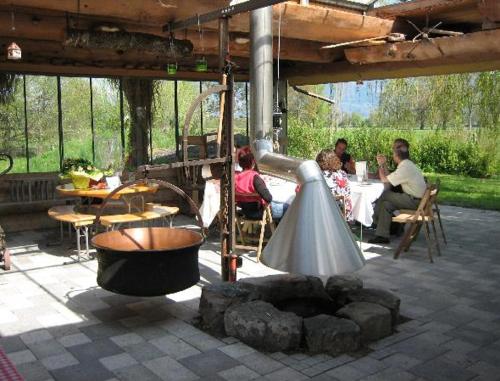 een groep mensen aan een tafel op een patio bij Steigmatt Bauernhof- Erlebnis in Montlingen