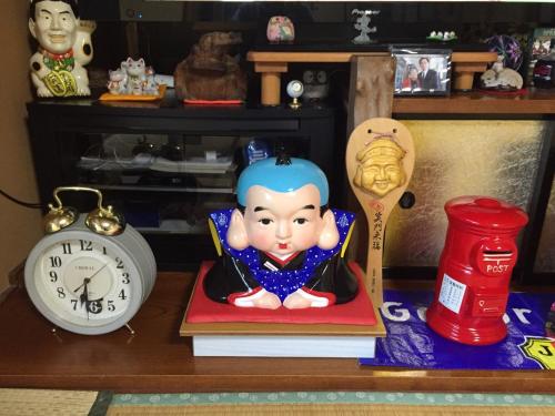 a shelf with a clock and a doll on a book at Cyokiya Lake Saiko in Fujikawaguchiko
