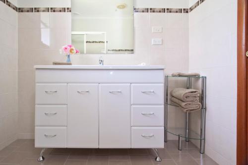 a white bathroom with a sink and a mirror at Clifton Gardens Bed & Breakfast - Orange in Orange