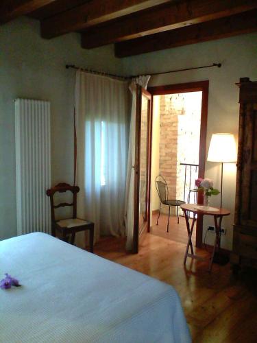a bedroom with a bed and a table and chairs at Il Rifugio del Poeta in San Biagio di Callalta