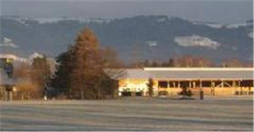 a large building in front of a field at Steigmatt Bauernhof- Erlebnis in Montlingen