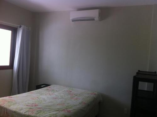 1 dormitorio con 1 cama y aire acondicionado en la pared en Apto em Condomínio Brisas do Amor, en Pipa