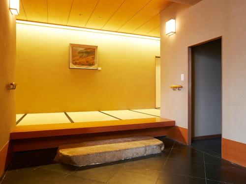 a yellow wall with a bench in a hallway at Osaka Academia in Osaka