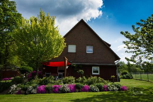 una casa con un jardín delante de ella en Heidetraum Pension & Ferienwohnung Arndt, en Bispingen