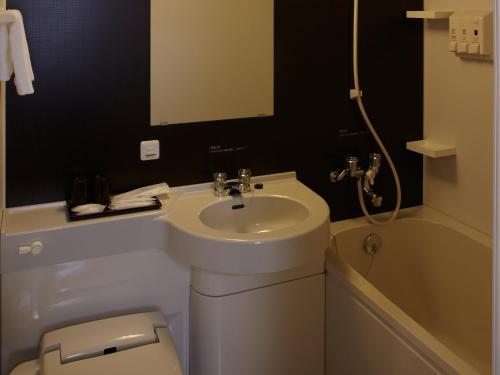a bathroom with a sink and a toilet and a tub at Osaka Academia in Osaka