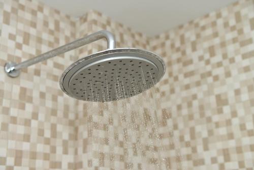 a shower head with water coming out of it at Fresh One Hotel in Batam Center