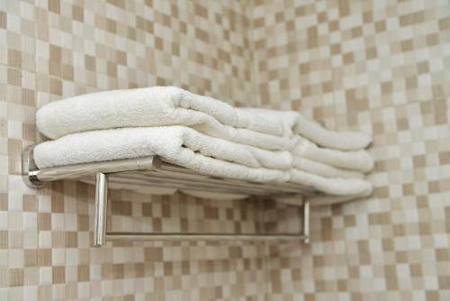 a group of towels on a towel rack in a bathroom at Fresh One Hotel in Batam Center