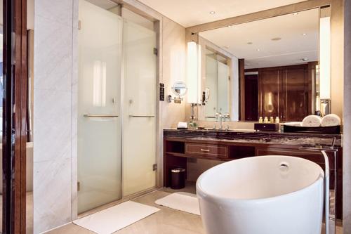 baño con bañera y espejo grande en Minyoun Chengdu Dongda Hotel, en Chengdú