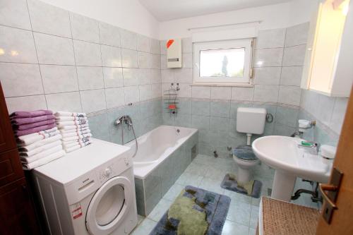 a bathroom with a tub and a toilet and a sink at Apartman Dinka in Trogir