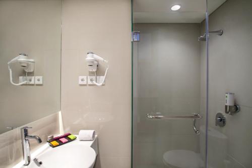 a bathroom with a shower and a sink and a toilet at ibis Styles Cikarang in Cikarang