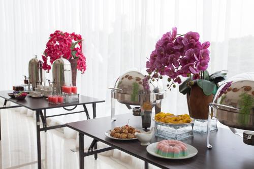 two tables with plates of food and flowers on them at ibis Styles Cikarang in Cikarang