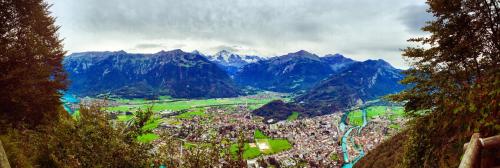 a view of a town in a valley with mountains at Alpina Hotel in Interlaken