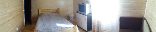a small room with a bed in a tiny house at Sadyba u Gansa in Svityazʼ