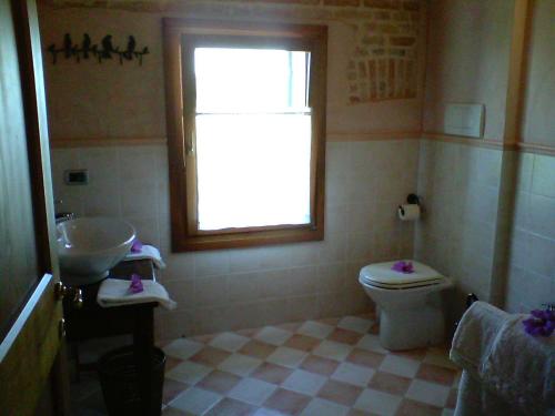 a bathroom with a sink and a toilet and a window at Il Rifugio del Poeta in San Biagio di Callalta