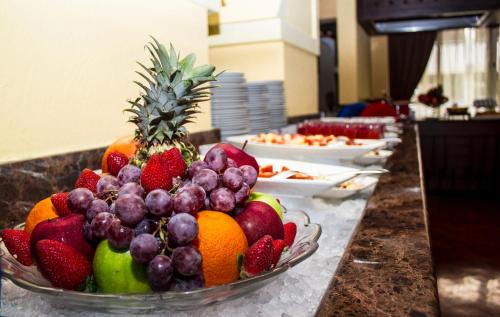 a bowl of fruit on a counter with plates of food at Riviera Hotel in Dubai