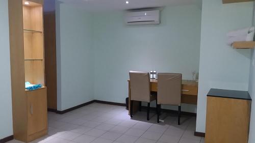 a kitchen with a table and chairs in a room at Fratini's Hotel Labuan in Labuan