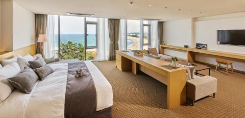 a hotel room with a large bed and a television at Naksan Beach Hotel in Yangyang