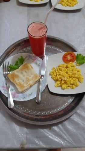 a tray with a plate of food with a drink at D'JERO HomeStay in Ubud