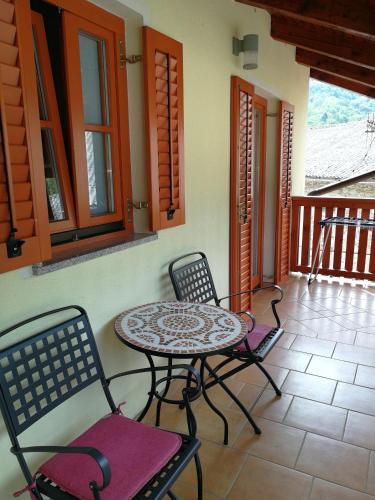 a patio with a table and chairs on a porch at Hiša Kranjc in Kobarid