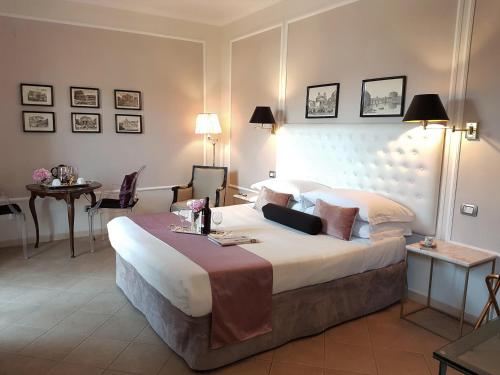 a hotel room with a large bed and a table at Althea Inn Roof Terrace in Rome