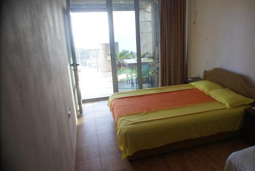 1 dormitorio con cama y vistas a un balcón en Apartments Olga, en Ulcinj