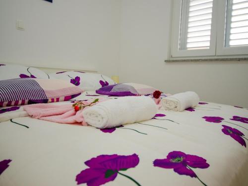 a bed with dolls on it with flowers on it at Apartments Vesela in Janjina