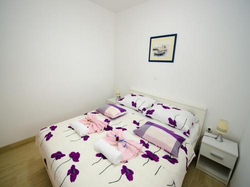 a bedroom with a bed with purple flowers on it at Apartments Vesela in Janjina