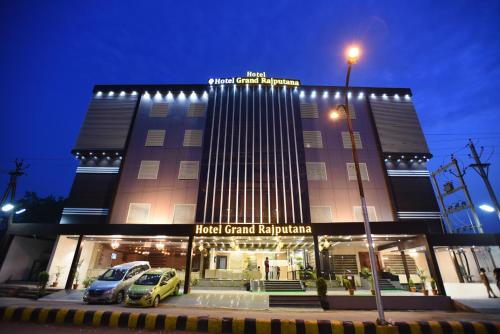 a building with cars parked in front of it at Hotel Grand Rajputana in Raipur