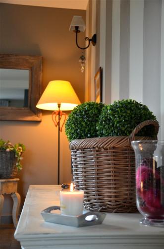 a candle on a table with a wicker basket and a candle at La Villa Belle in Belle-et-Houllefort