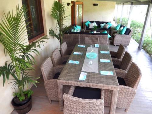 a patio with a table and chairs and a couch at Riverbend Suite Rooms in Rosebank