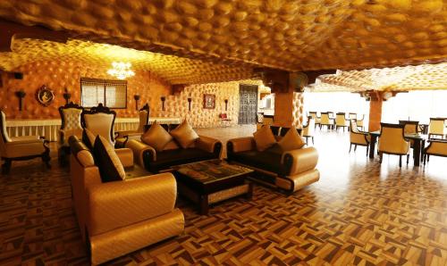a living room with couches and chairs and a table at Treebo Blessing Bells in Dehradun