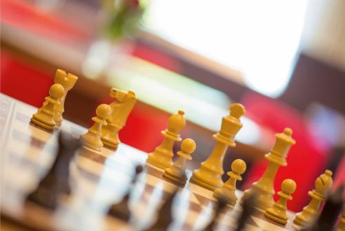 a close up of a chess board with yellow chess pieces at Hotel Sonnenhof in Merano