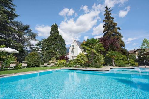 a large swimming pool in front of a house at Hotel Sonnenhof in Merano