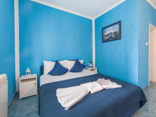 Apartments MIK5 في بودفا: غرفة نوم زرقاء مع سرير بجدران زرقاء