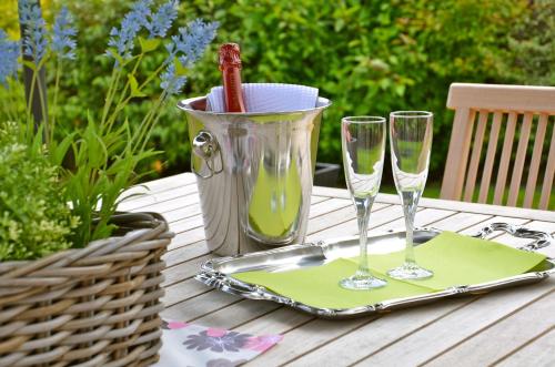 a table with two glasses and a bucket of wine at La Villa Belle in Belle-et-Houllefort