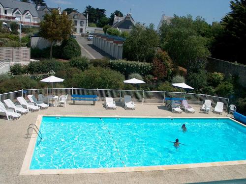 une personne nageant dans une grande piscine dans l'établissement Cook appartement, à Étel