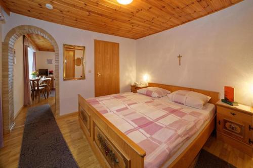 ビショフスマイスにあるBerghof Pension und Ferienwohnungenのベッドルーム1室(壁にクロス付きの大型ベッド1台付)