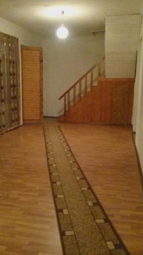 an empty room with a wooden floor and stairs at N&N Guest House in Mestia