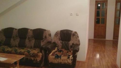 a couch sitting in a living room with a table at N&N Guest House in Mestia