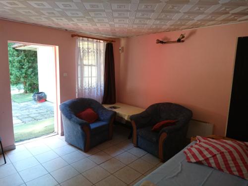 a bedroom with two chairs and a table and a bed at Ośrodek Wypoczynkowy Duet in Zamość