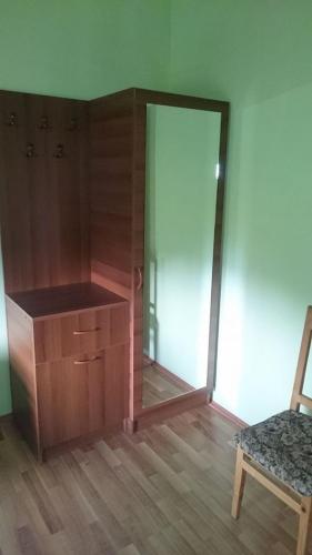 a room with a wooden cabinet and a chair at N&N Guest House in Mestia