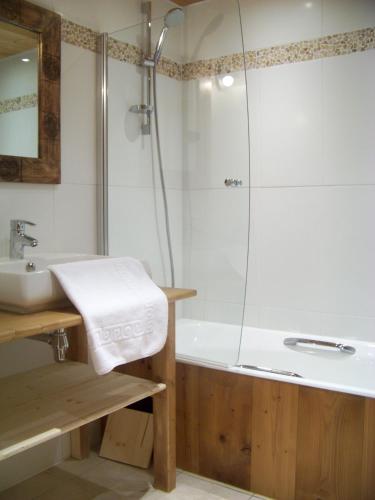une salle de bain avec une douche, un lavabo et une baignoire dans l'établissement Chalet Odette, à Morzine