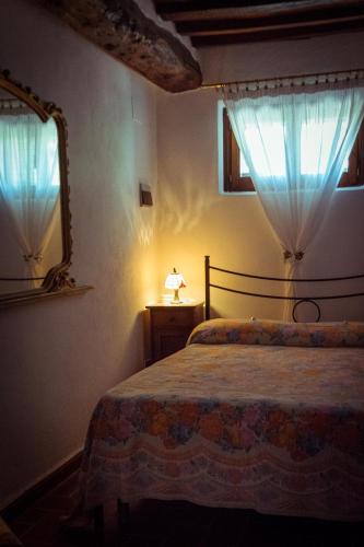 a bedroom with a bed and a mirror and a window at Agriturismo Palazzo Val Del Sasso in Villastrada